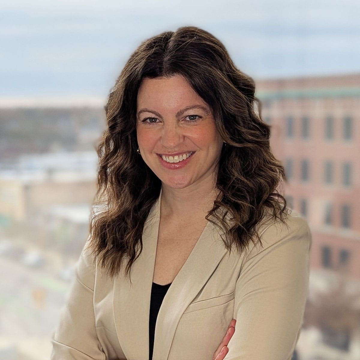 Smiling professional in business attire, set against a city backdrop.